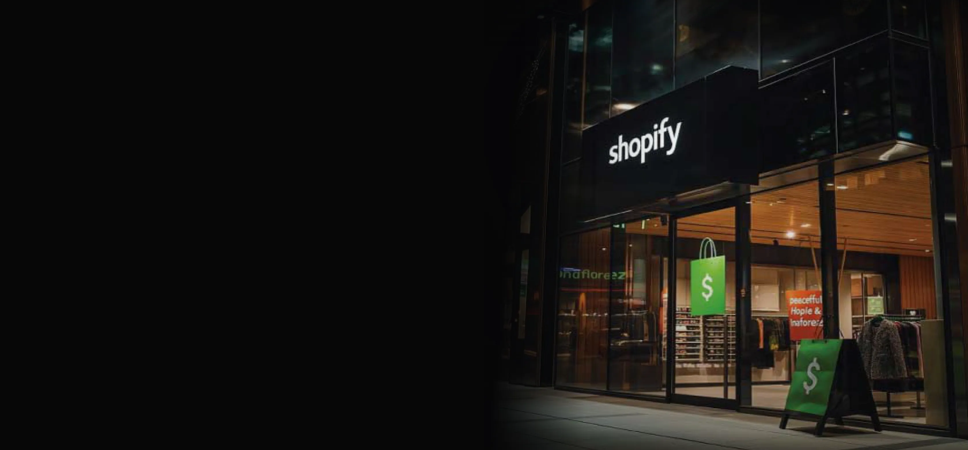 Shopify storefront lit up at night, fading into the dark section background