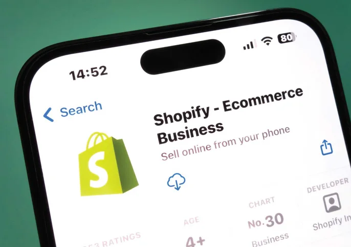 An iPhone displaying the Shopify — Ecommerce Business app listing on the App Store